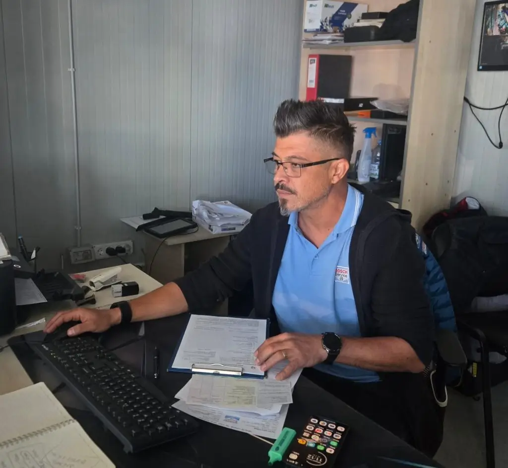 Membru al echipei Auto Gan la birou, cu documentele vehiculului