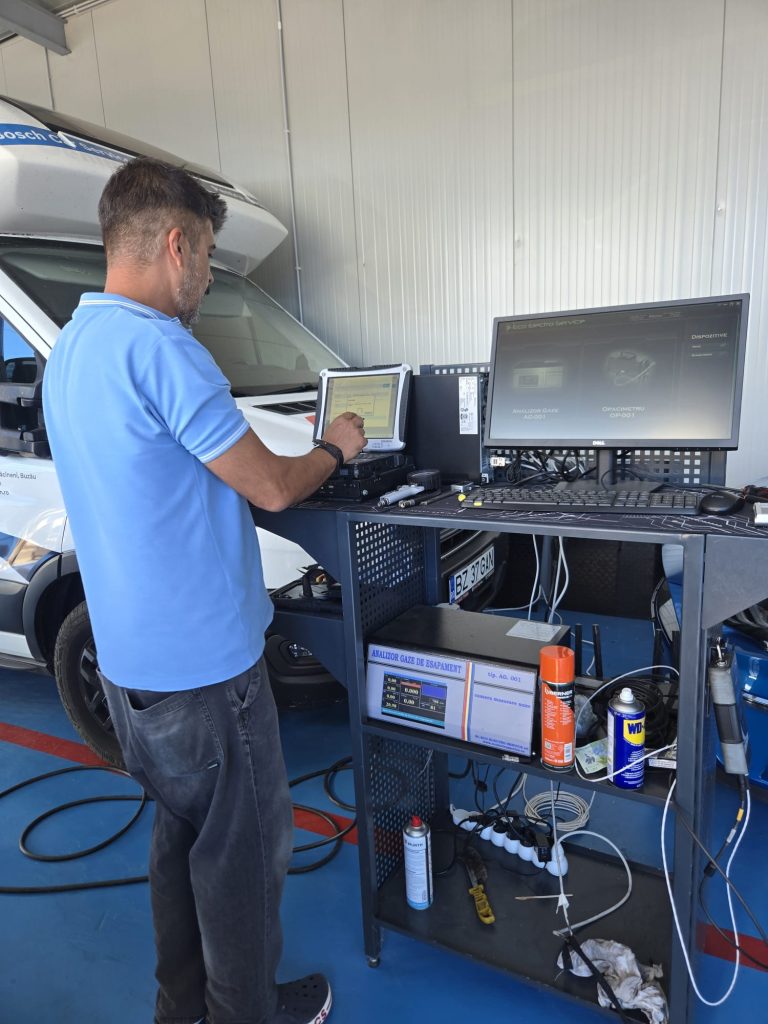 Tehnician lucrând la calculatorul echipamentului din stația ITP Auto Gan